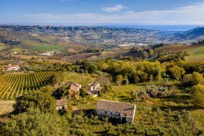 Stone village with farmhouses for sale in a hillside location with sea views, in the Marche region